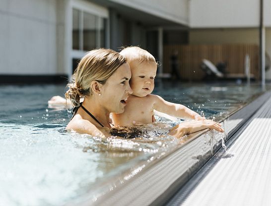 Mutter und Baby im Außenpool im Thurnerhof Hotel Saalbach.