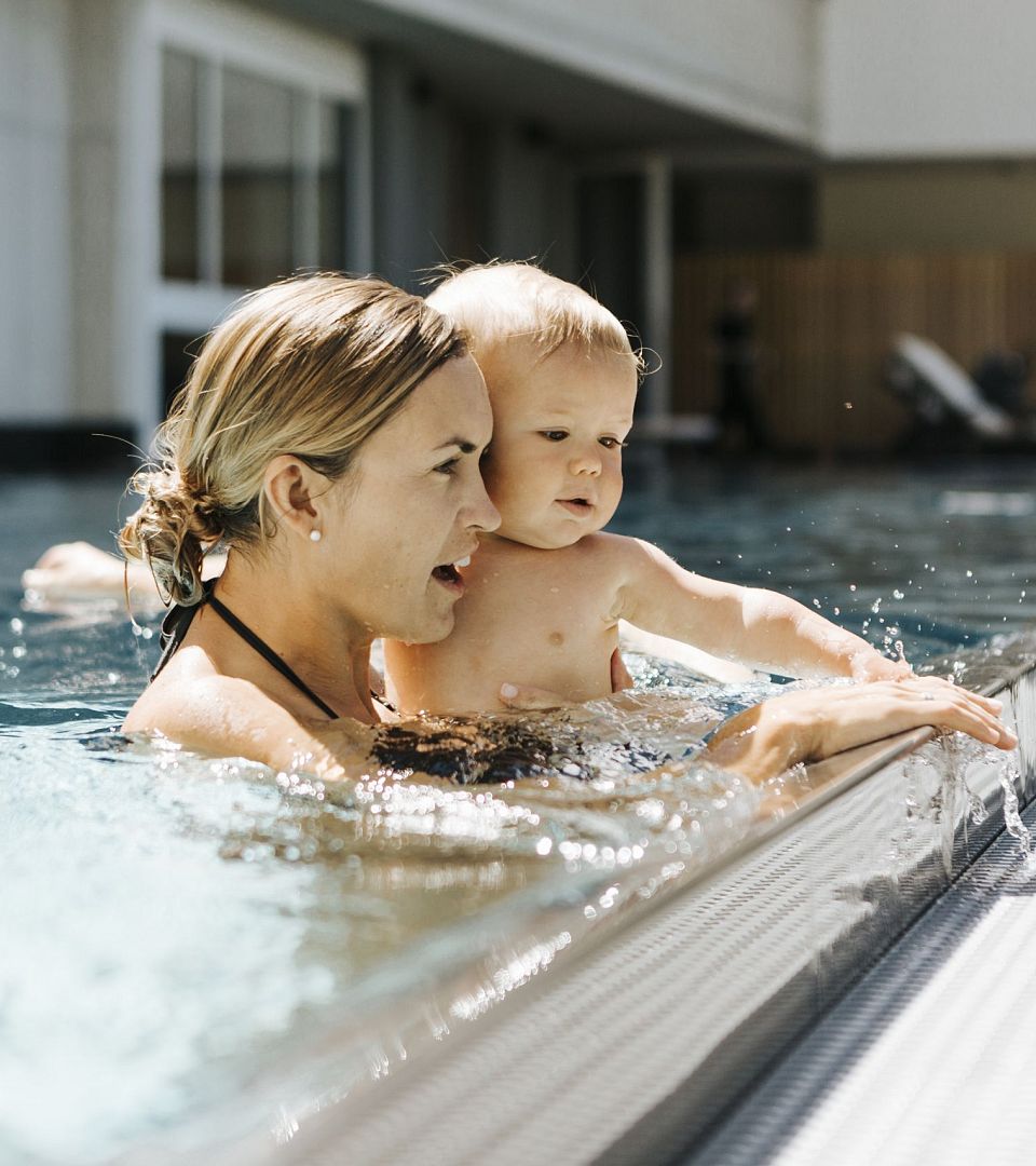 Mutter und Baby im Außenpool im Thurnerhof Hotel Saalbach.
