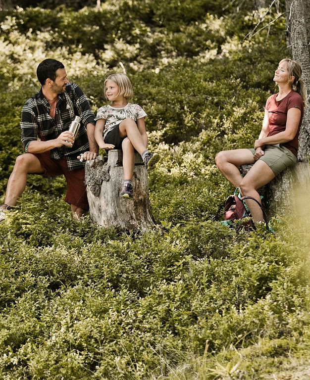 Mama, Papa und Kind gemeinsam im Wald beim Familienurlaub im Sommer in Saalbach.