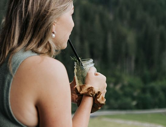 Frau trinkt eine kühle Limonade auf der Terrasse des Hotel Thurnerhof